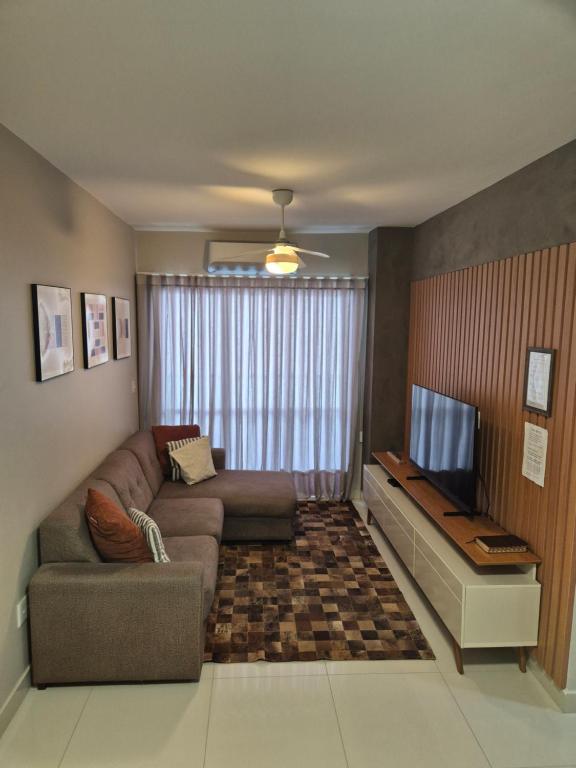 a living room with a couch and a television at Apartamento Confortável e Espaçoso em Condomínio Familiar, 2 Quartos com 1 suíte e Lazer de Clube in Belém