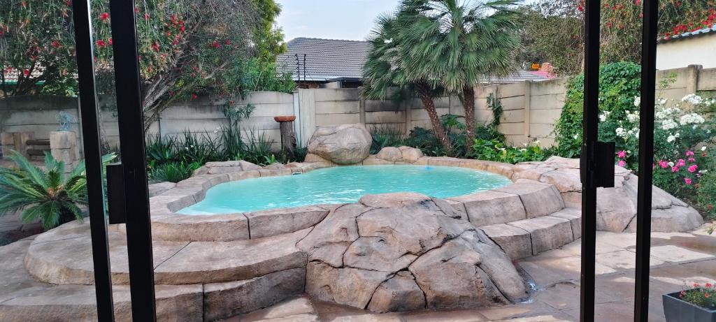 una piscina en un jardín con una roca alrededor en 7atSapele, en Germiston