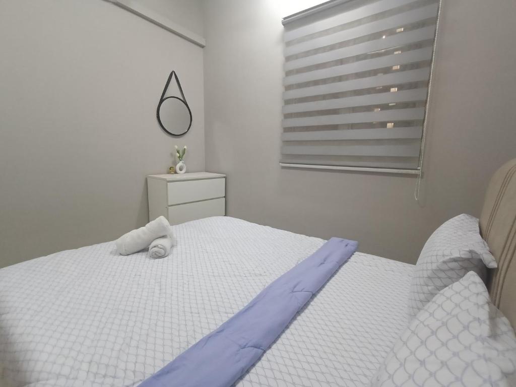 a bedroom with a white bed and a window at Delta 1009 Comfort Transit with reasonable Airport Pickup Service in Kampong Bekoh