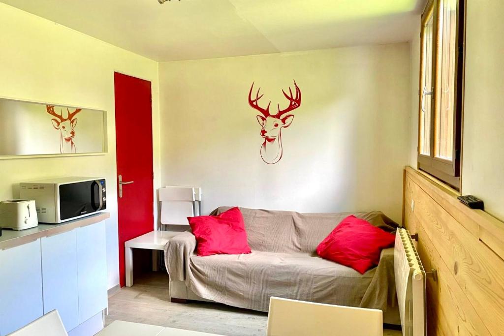 Una habitación con una cama y dos cabezas de ciervo en la pared. en Bright apartment near the slopes, en La Salle-les-Alpes