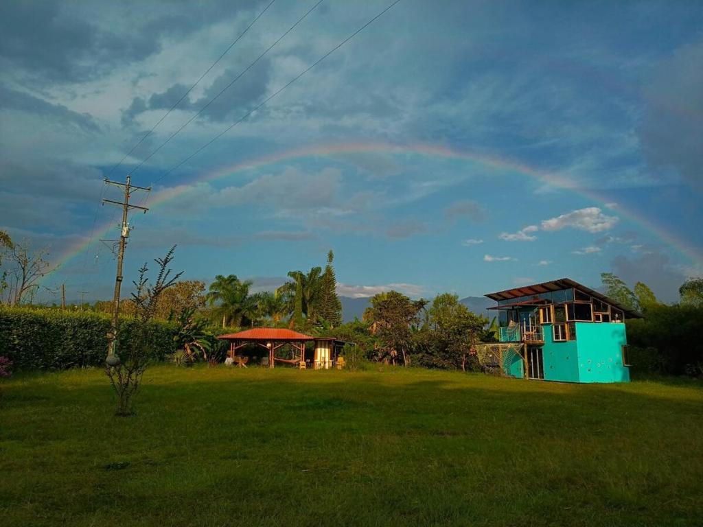 a rainbow in the sky over a field with houses at El Huerto del Edén in Armenia