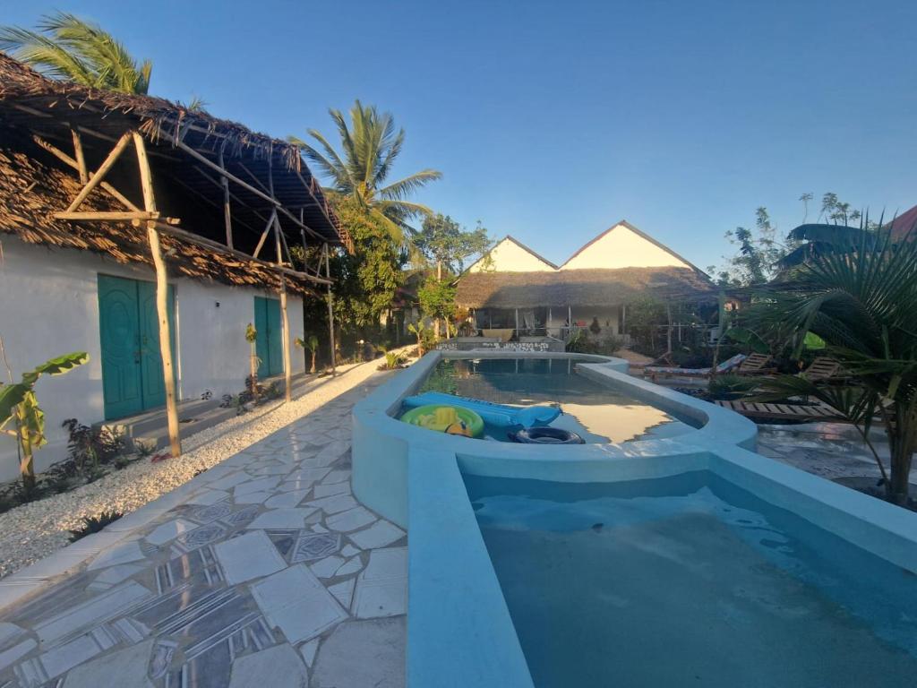 a swimming pool next to a villa with a resort at Lemon grass house in Binguni