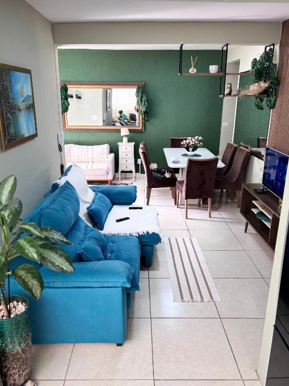 a living room with a blue couch and a table at Casa verde 4 quartos in Goiânia