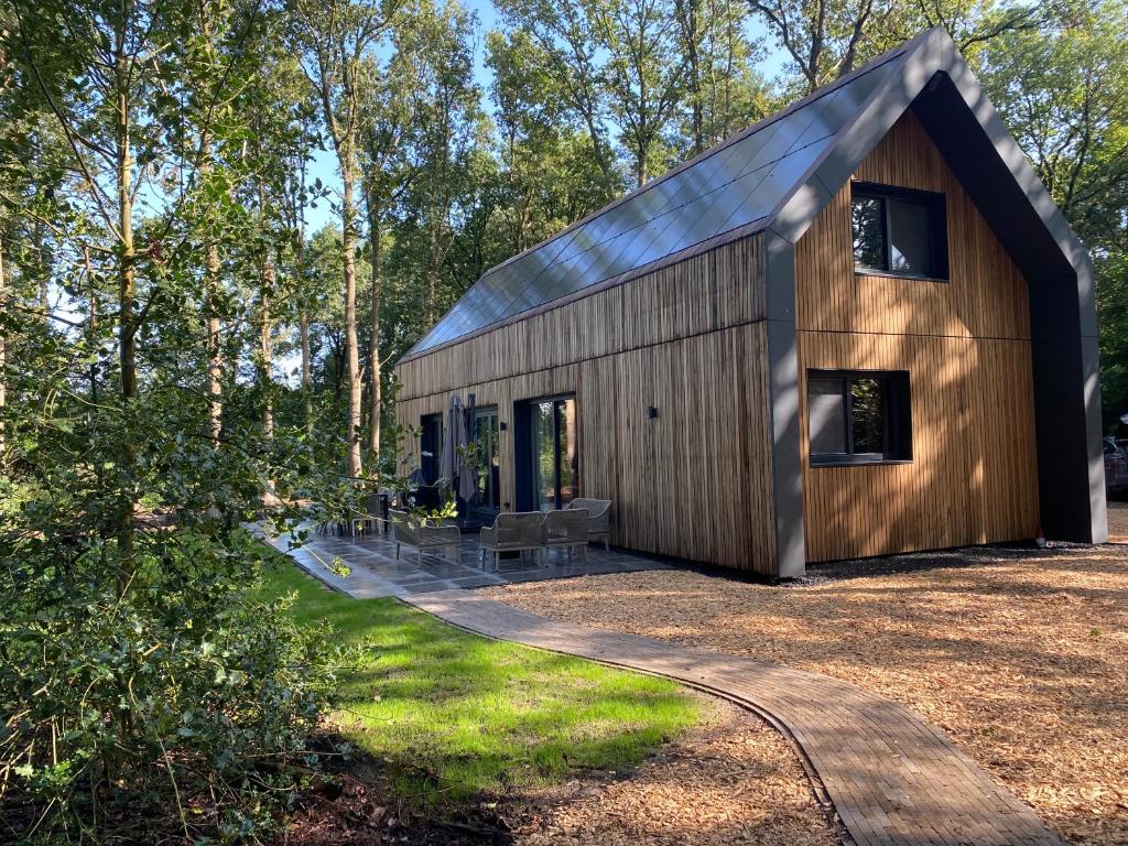 a wooden house with a gambrel roof at NIEUW Eco design bosvilla met sauna en xl tuin in Wateren