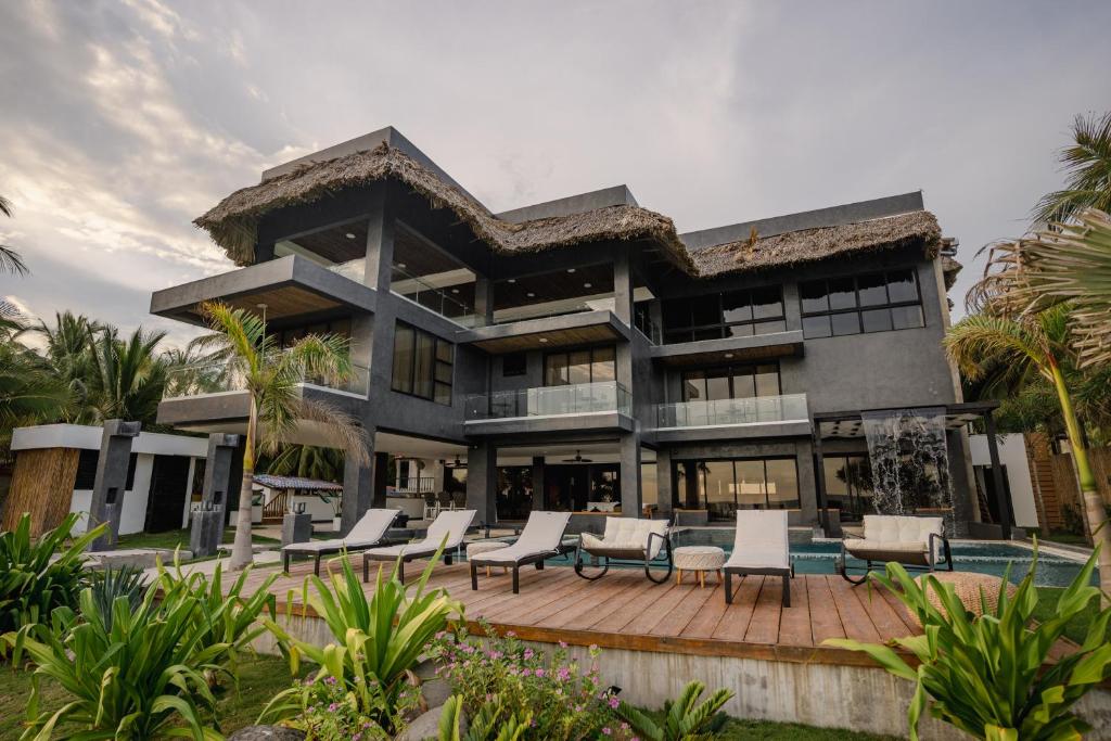 a large house with a patio and chairs at Cardedeu Residence Cangrejera in La Libertad