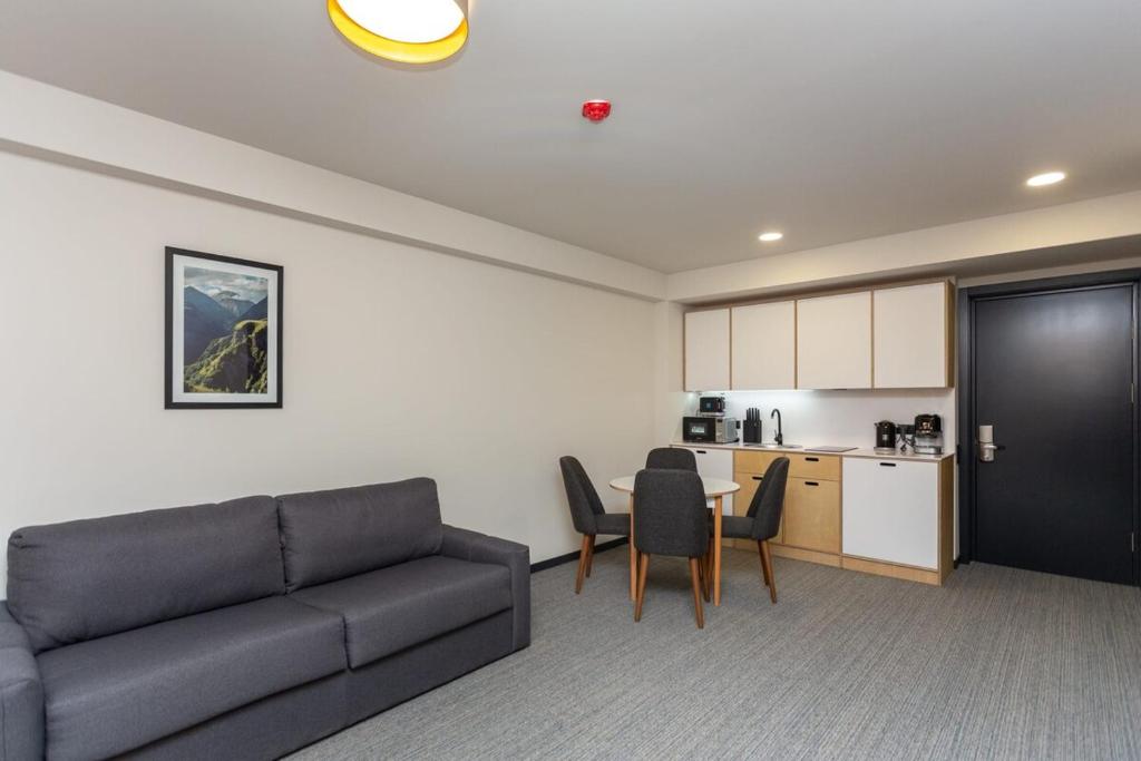a living room with a couch and a table and a kitchen at 1BR Apart In Kokhta Mitarbi in Bakuriani