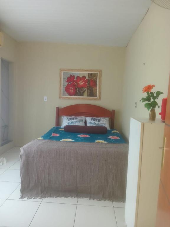 a bedroom with a bed and a painting on the wall at Kit Net perto da vila cop30 in Belém