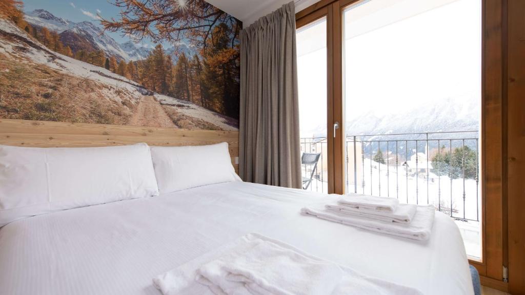 a bedroom with a white bed and a large window at L'essenza Chalet - San Pietro 8A Valdisotto in Bormio