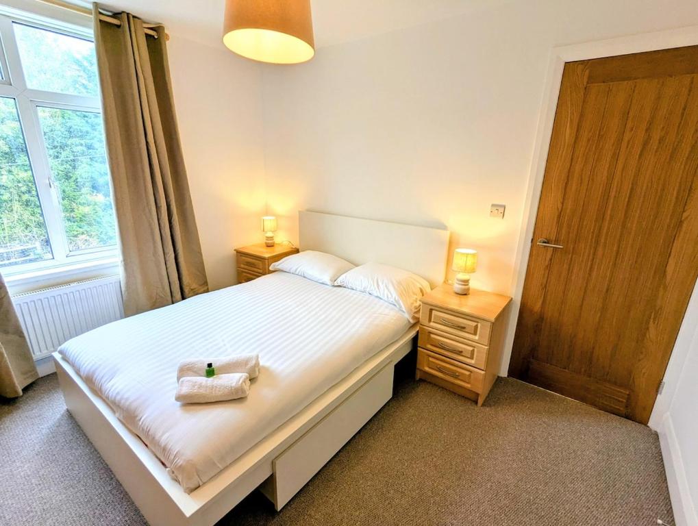 クルーにある3 bed cosy homeのベッド、ナイトスタンド2台、ランプ2個を備えた寝室