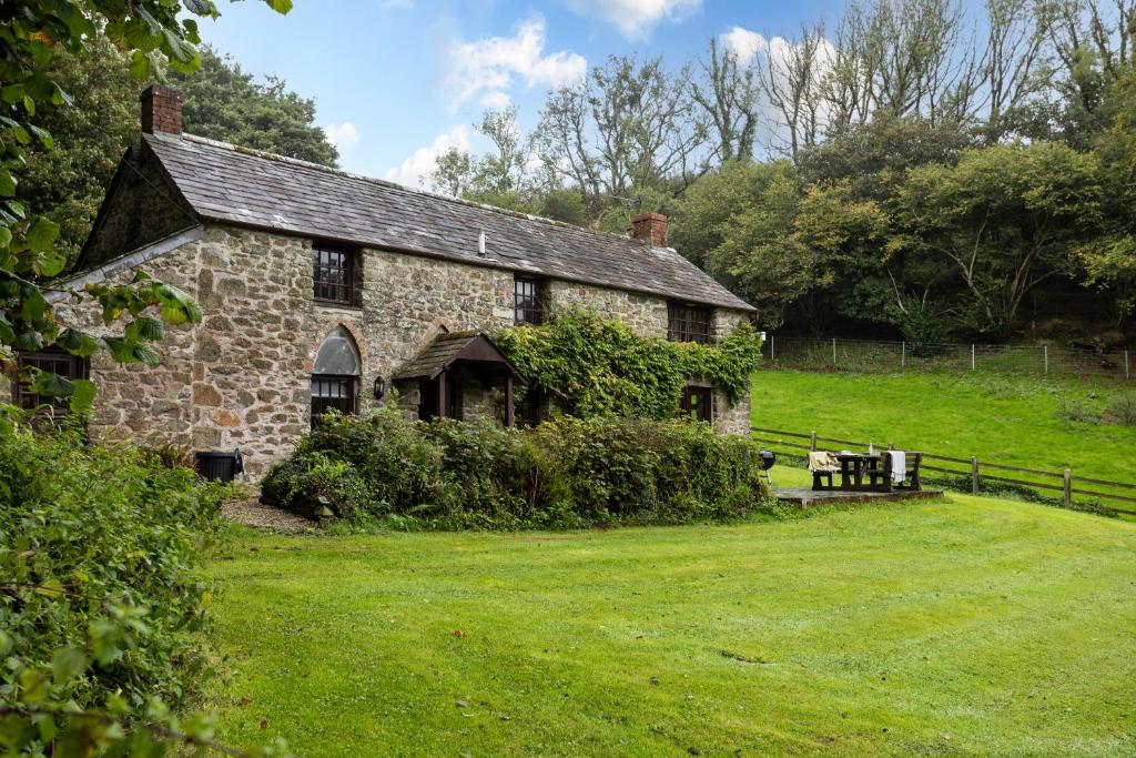 an old stone house on a grass field at Myrtle Grove in Saint Endellion