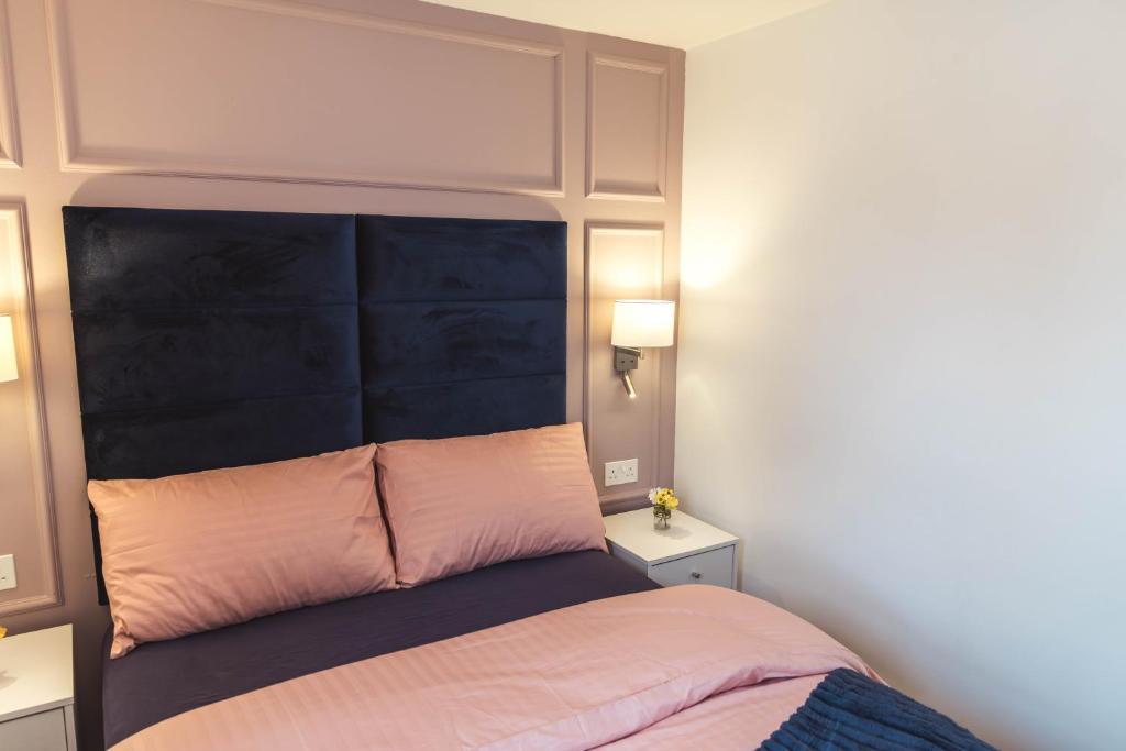 a bed with a black headboard in a room at The Wee Snug Portrush in Portrush