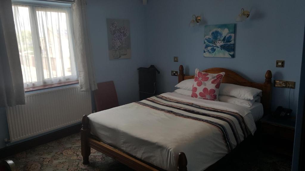a bedroom with a bed with a pink pillow at Balkan Lodge Oxford in Oxford