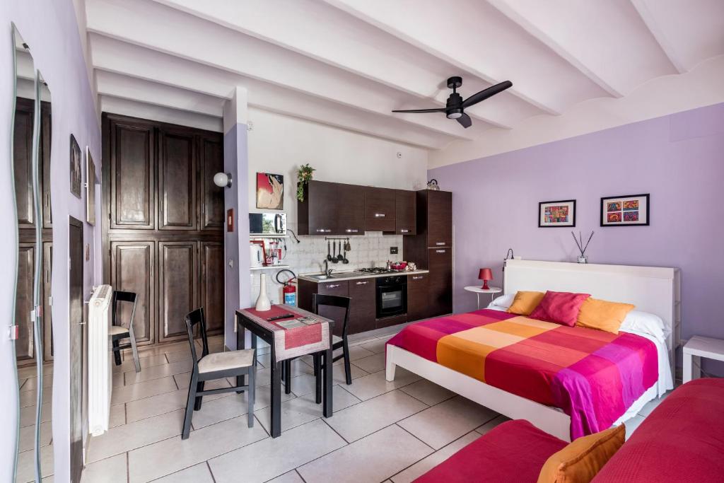 a bedroom with a bed and a desk and a kitchen at Appartamento Tivoli Train Station in Tivoli