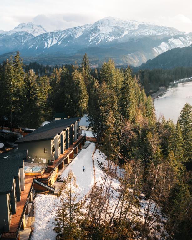 an aerial view of a ski lodge with a river and mountains at Basecamp Resorts Revelstoke in Revelstoke