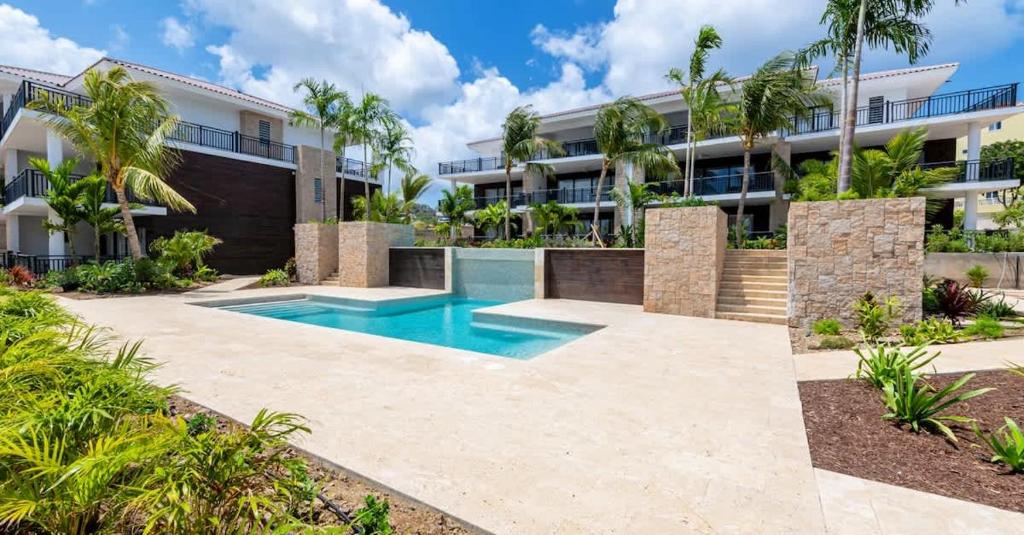 a swimming pool in front of a building at The Breeze Escape in Blue Bay