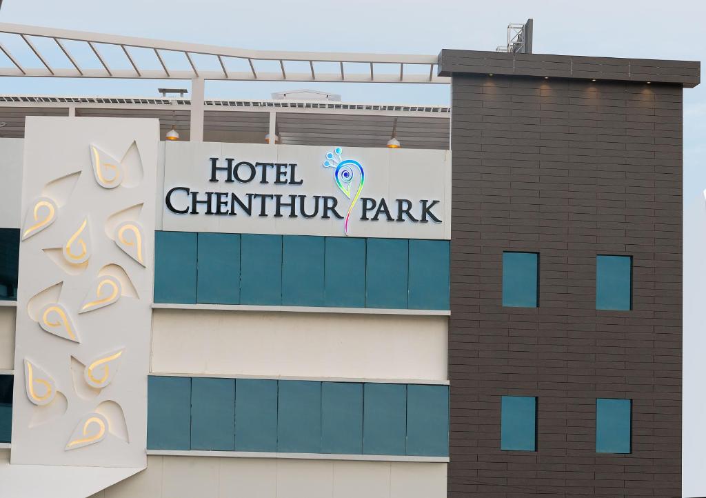 un cartello per un hotel Butterfly Park sul lato di un edificio di Hotel Chenthur Park a Coimbatore