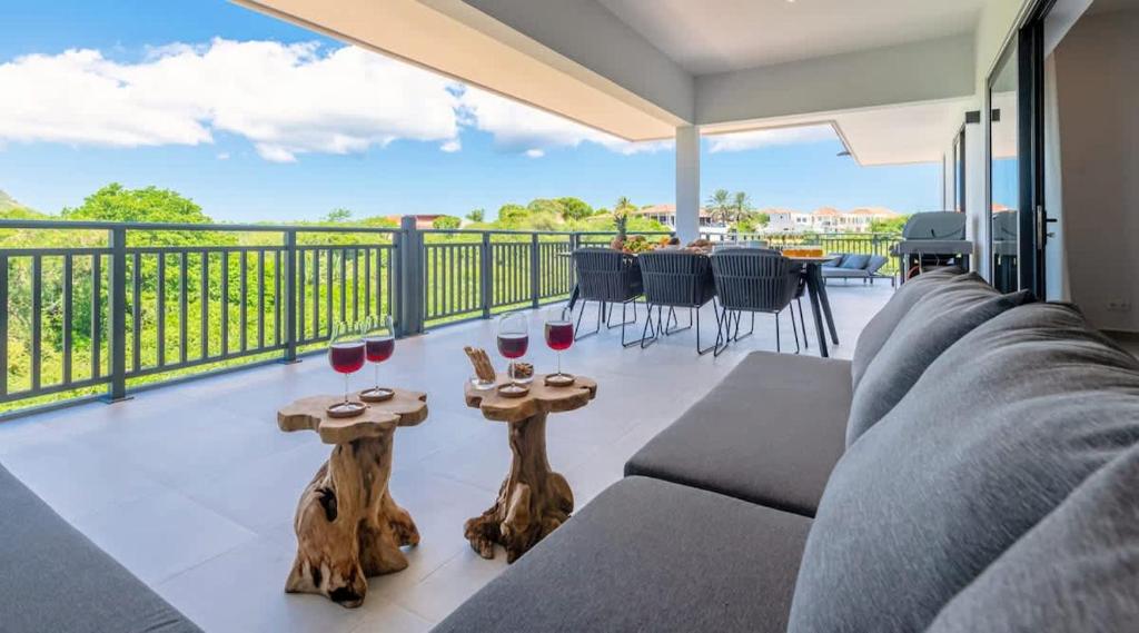 a living room with a couch and two tables with wine glasses at The Breeze 50 in Willemstad