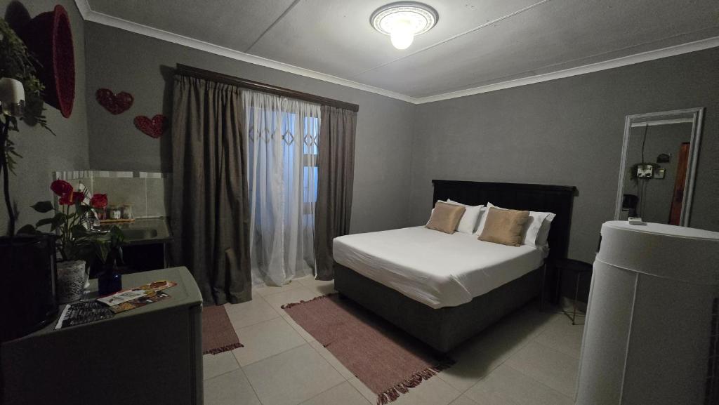 a bedroom with a bed and a window at Akwaaba Fie Guesthouse in Lebowakgomo