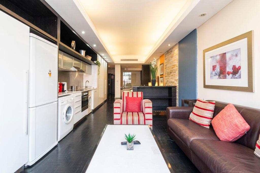 un salon avec un canapé et une table dans l'établissement Heritage-Chic Apartment in Cape Town, au Cap