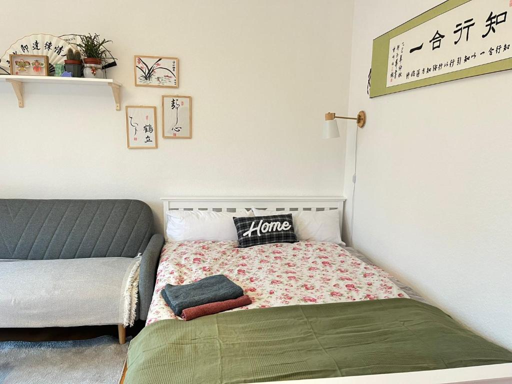 a small bedroom with a bed and a couch at Schönes, Zentral gelegenes KulturZimmer in Erfurt