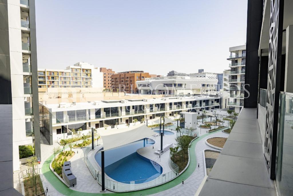 Una vista aérea de un edificio con piscina. en Bloomfields Elegant Pool View Stu The Gate, en Abu Dhabi Intl