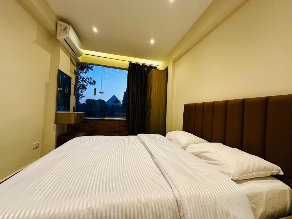 Un dormitorio con una cama grande con ventana. en The Pyramid Vault View INN, en El Cairo