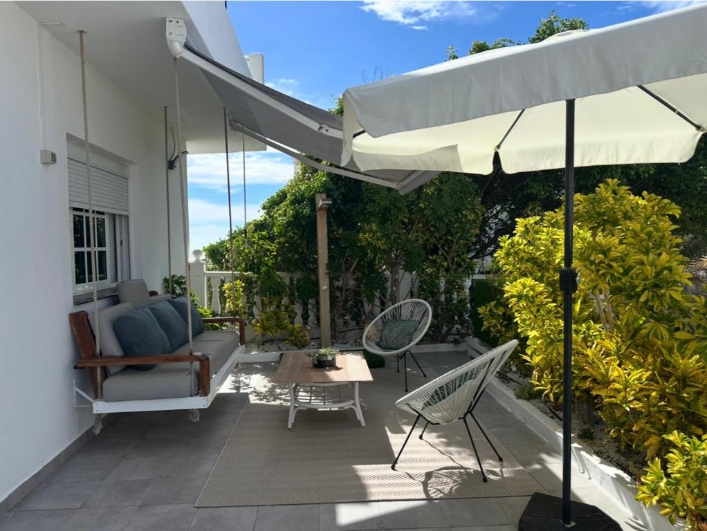 a patio with an umbrella and chairs and a table at Casa Alba in La Mareta