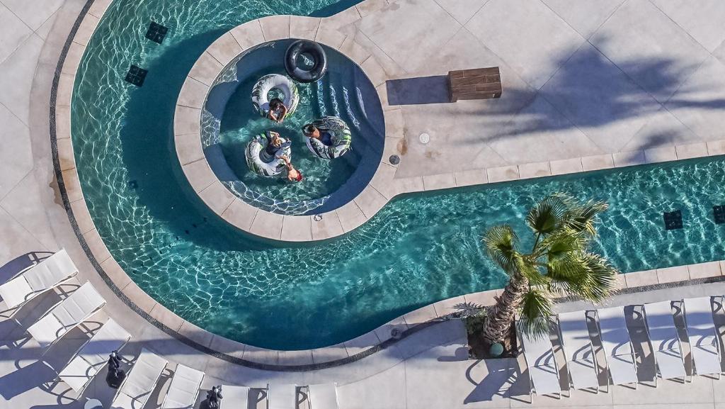 an overhead view of a swimming pool with two people at Encantame Towers Verano 1401 in Playa Encanto