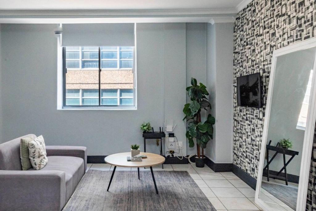 a living room with a couch and a table at City Oasis Suite Cape Town in Cape Town