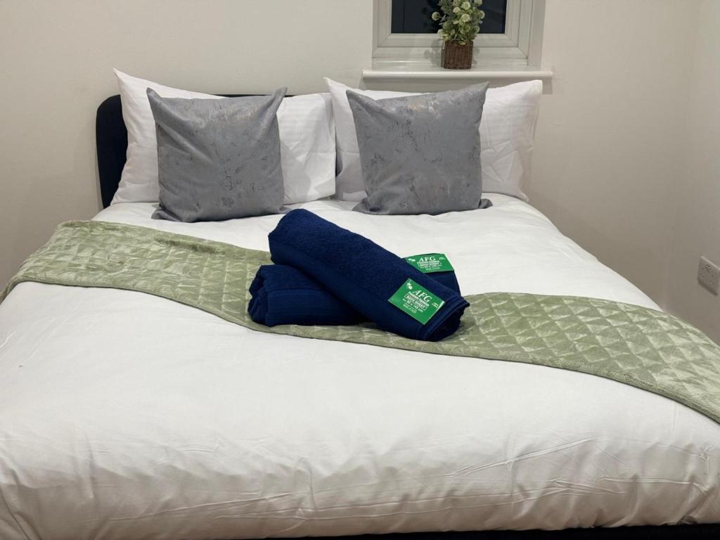 Crown Residency London في لندن: سرير عليه وسادتين زرقاوين