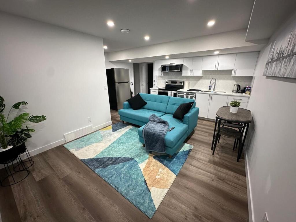 a living room with a blue couch and a kitchen at Guest Suite with Private Entry in Calgary in Calgary