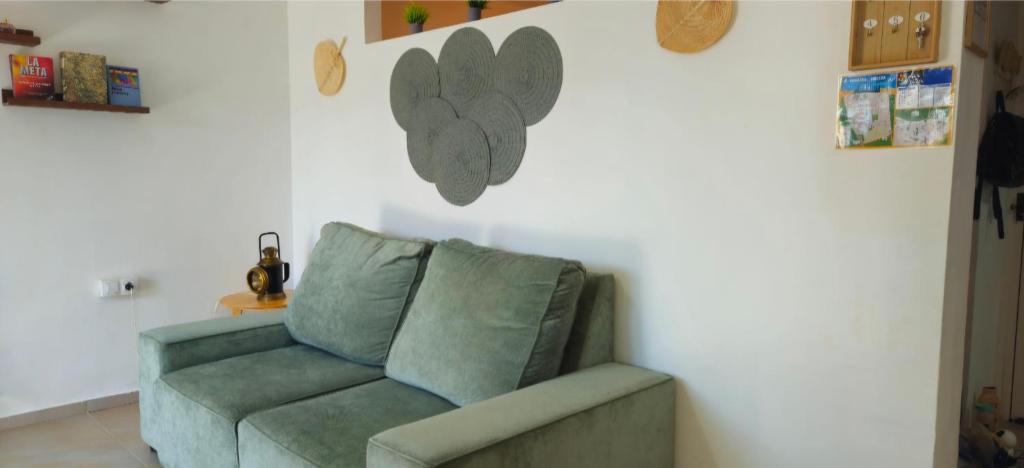 un sofá sentado en una sala de estar junto a una pared en Urban loft Valencia playa, en La Pobla de Farnals