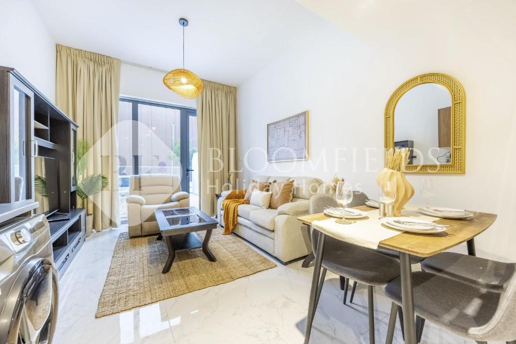 una sala de estar con un sofá y una mesa en Bloomfields Elegance 1br in Oasis Masdar, en Abu Dabi