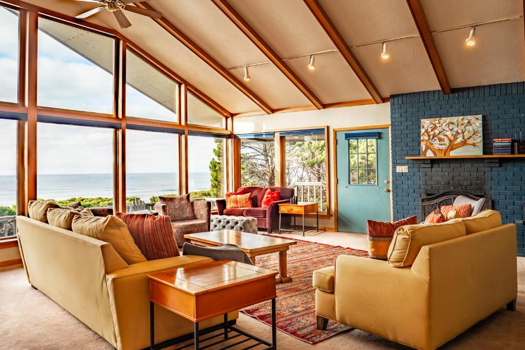 a living room filled with furniture and windows at Hot Tub & Game Room in Large Ocean Front Home! Second Story in Holiday Beach