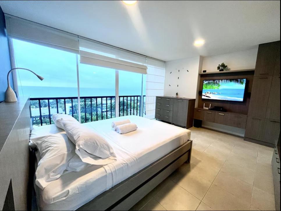a bedroom with a large bed and a television at Suite Exclusiva detrás del Decameron Punta Centinela 9F in Punta Blanca