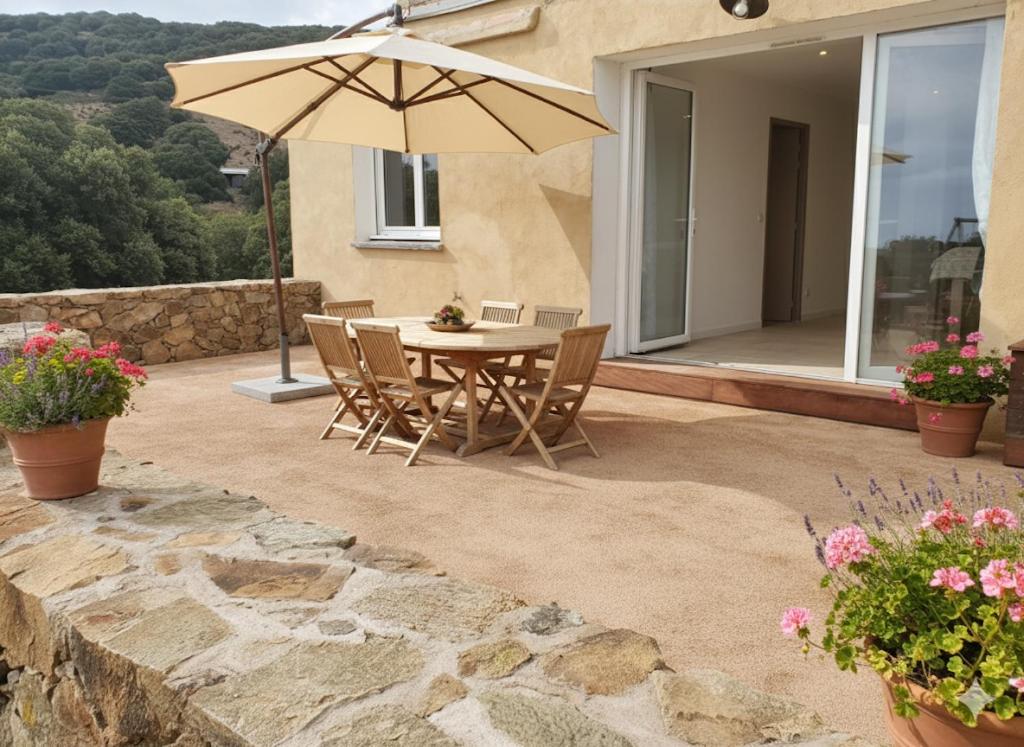 eine Terrasse mit Tisch und Sonnenschirm in der Unterkunft location Appartement Cargèse in Cargèse