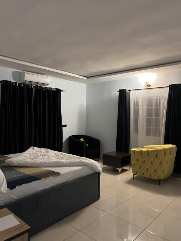 MamaにあるM3 Suitesのベッドと椅子のある寝室