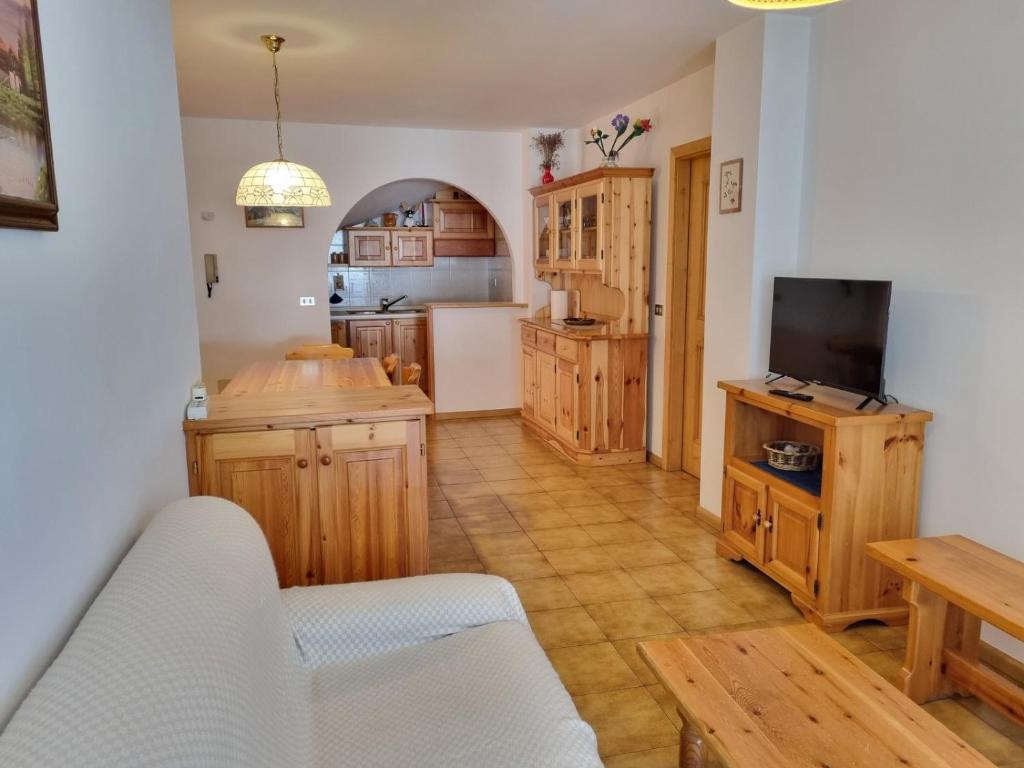 a kitchen with wooden cabinets and a tv on a table at Villa Erica in Alba di Canazei