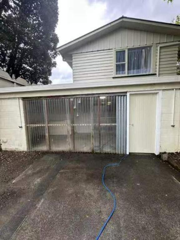 a house with a garage with a blue hose at 77b Slacks Road, Awapuni, Palmerston North in Palmerston North