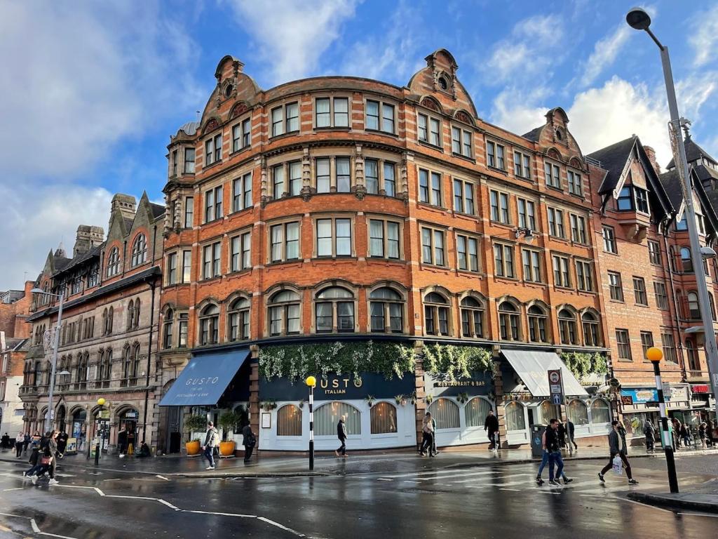 a large red brick building on a city street at Heart of Notts, Spacious Studio, Great City Views in Nottingham