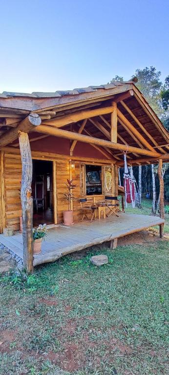 a log cabin with a porch and a table at Cabana Vale Matutu in Aiuruoca