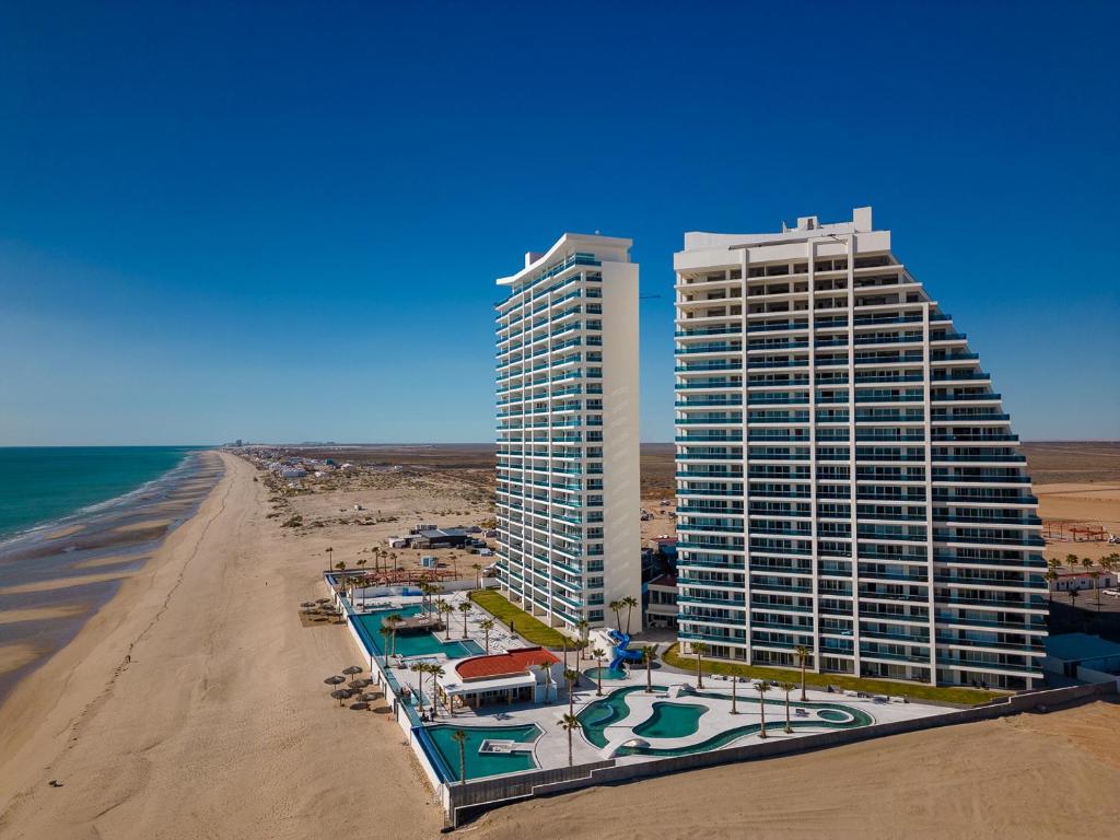 an aerial view of two tall buildings on the beach at Cozy beach front getaway Encantame Towers E304 in Playa Encanto