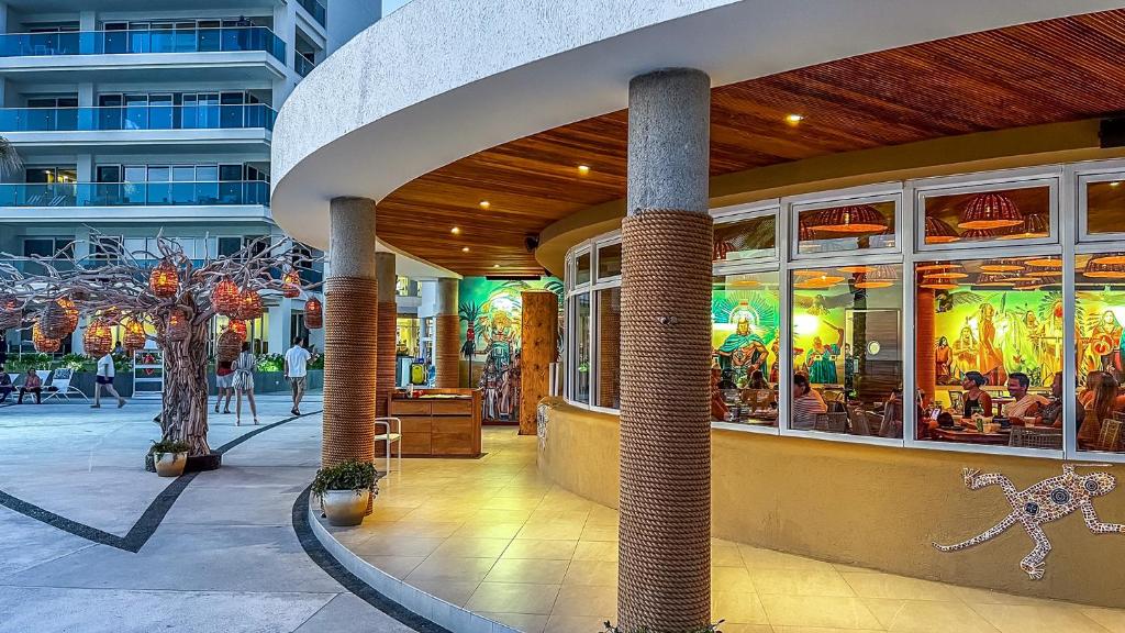 a building with a restaurant with windows and people walking in the street at Sublime 3 bedroom condo Encantame Towers Verano 801 in Playa Encanto