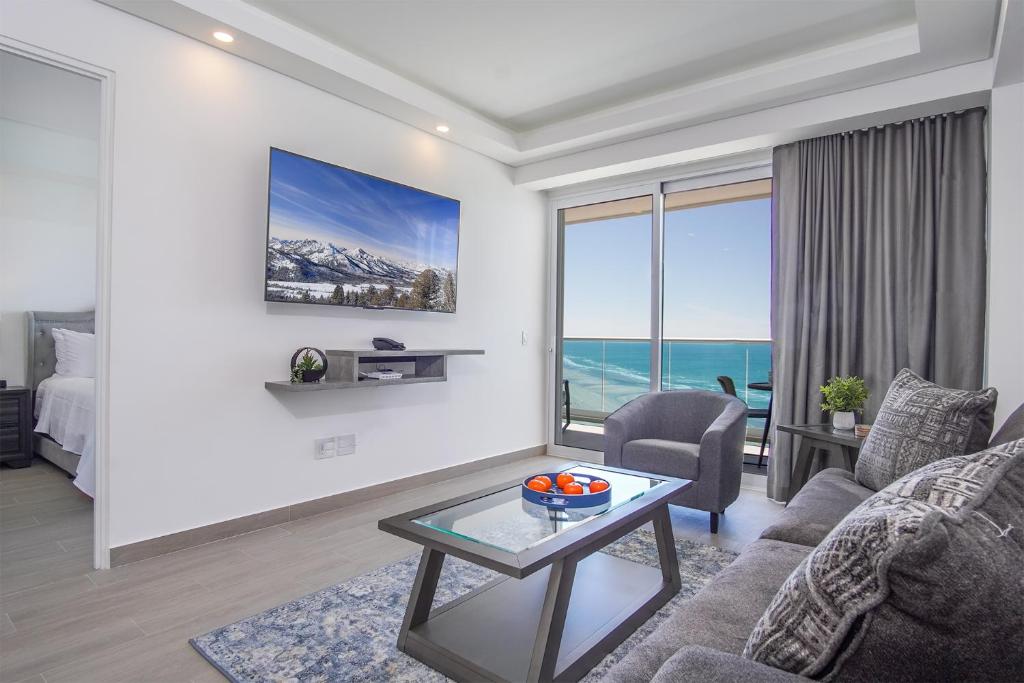 a living room with a couch and a table at Panoramic beach front condo Verano 1703 in Puerto Peñasco