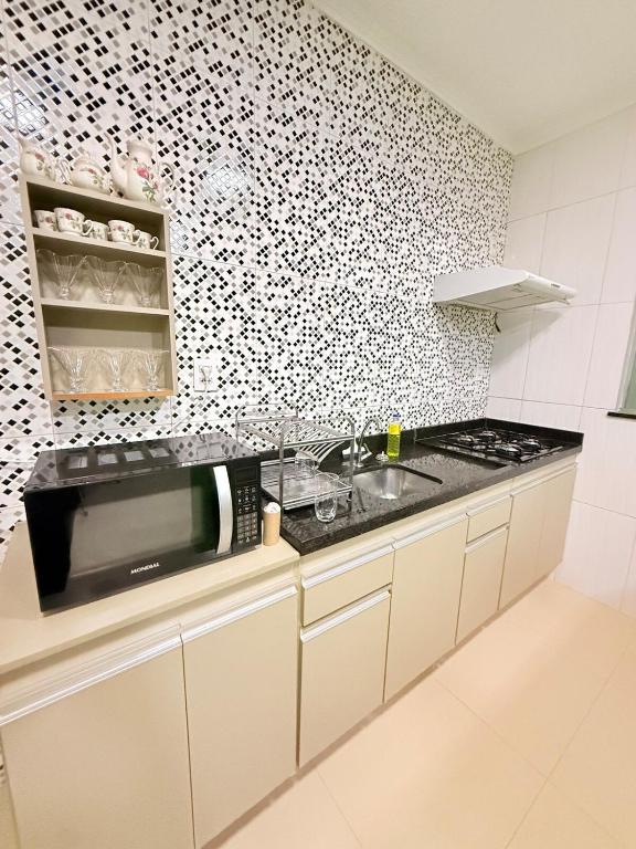 a kitchen with a sink and a counter top at Nina lar in Boa Vista