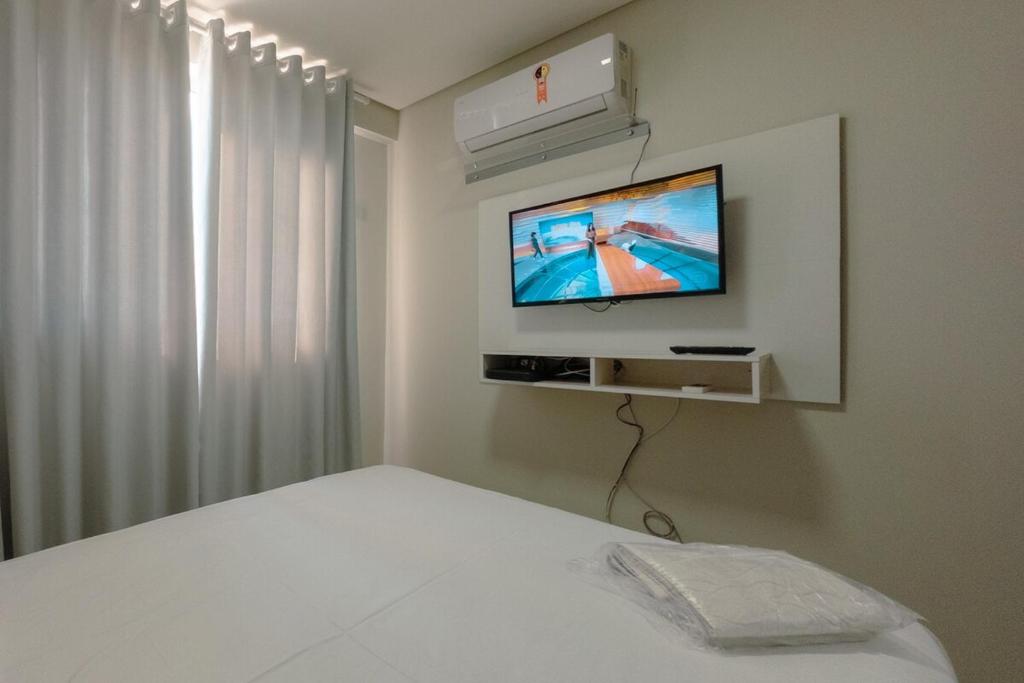 a bedroom with a bed and a tv on a wall at Aproveite este achado! - GC1108 in Maringá