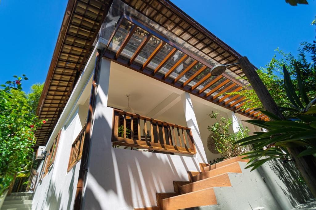 a white house with a wooden balcony and stairs at Casas Divino in Cayru