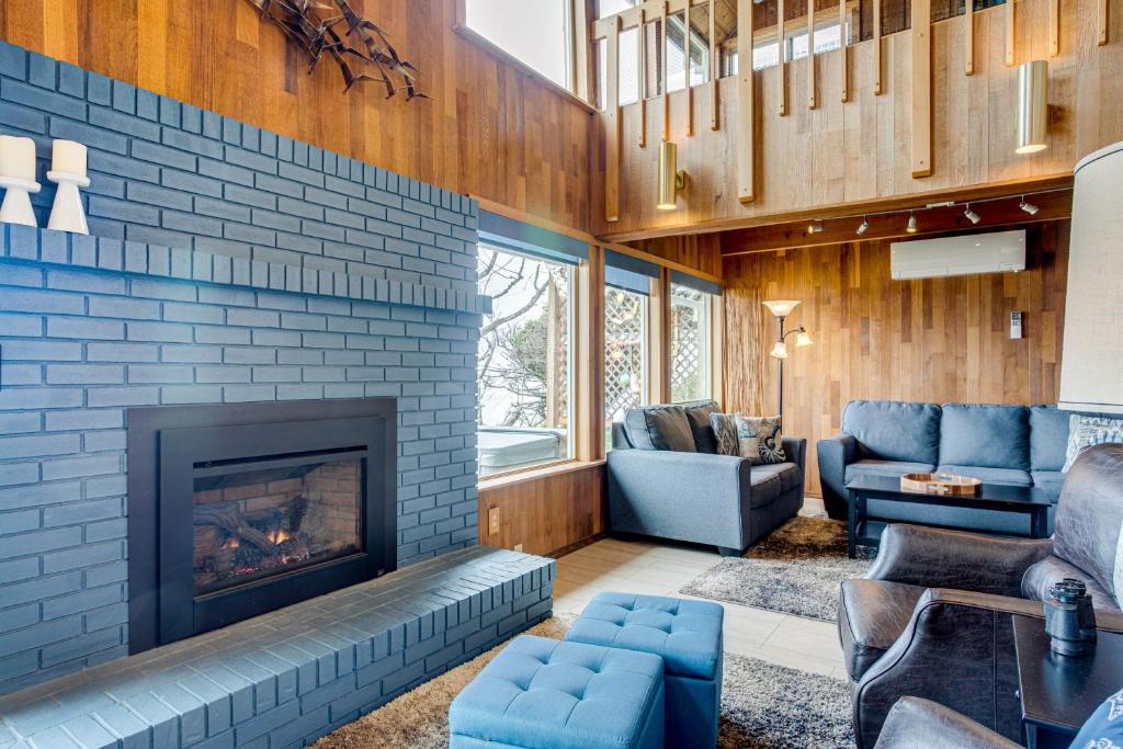 un salon avec une cheminée et des meubles bleus dans l'établissement Ocean Front Home on Sandy Beach! Tidal Destination, à San Marine