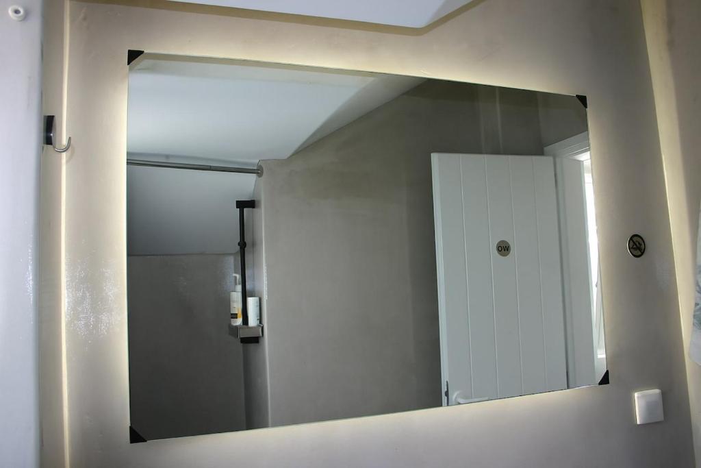 un miroir sur un mur dans une salle de bain dans l'établissement Persephone's Summer House Paros - 2BR Garden Villa, à Parasporos