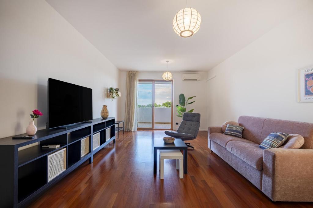 a living room with a couch and a television at Casa Diletta— Bright Spaces, Warm Moments in Stazione Bari Centrale